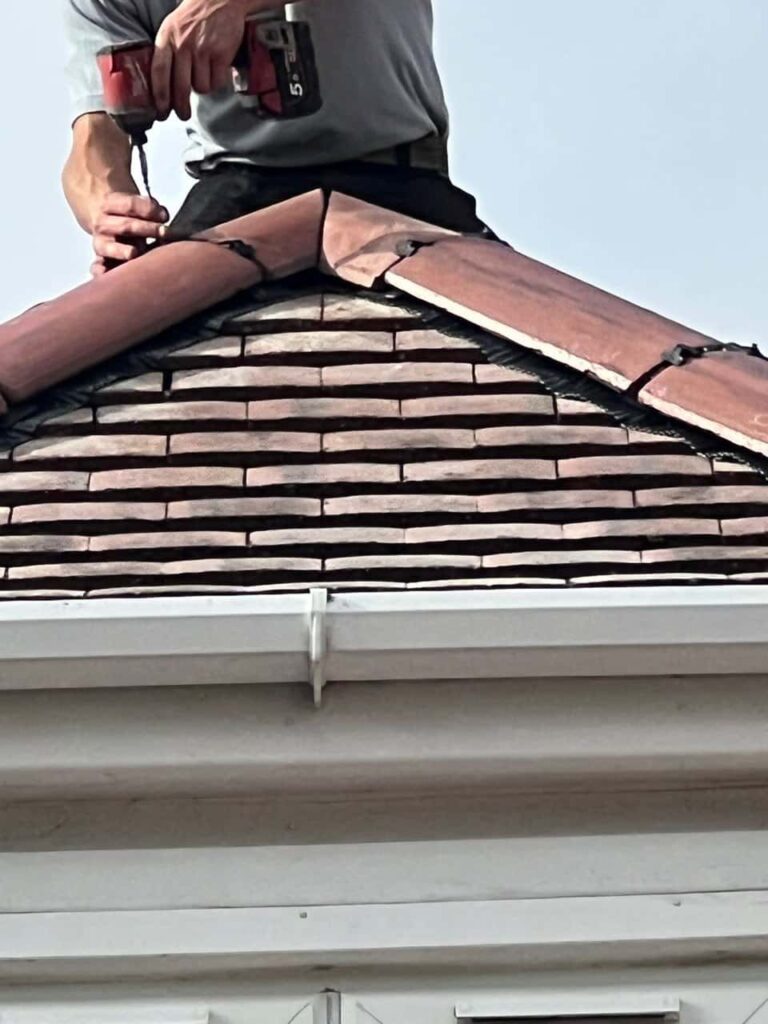 This is a photo of one of the operatives of Foots Cray Roofing Repairs installing new ridge tiles